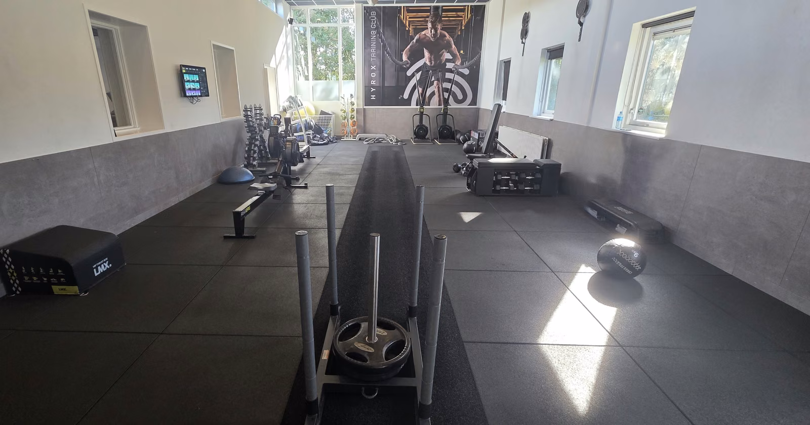 Hyrox blessures in Waddinxveen: trainingsruimte met sled op de baan, SkiErgs en roeitoestel